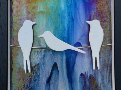White silhouette swallows x3 on wire, rainbow iridised background