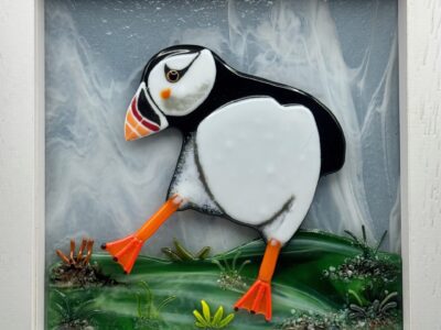 Puffin stepping out of frame, with background